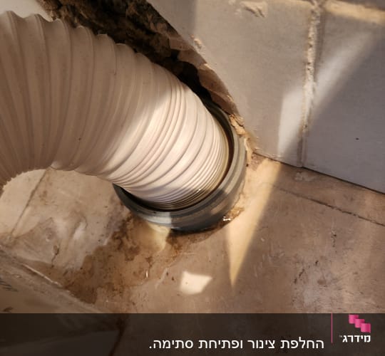 צינור לבן מחובר לקיר עם אריחים